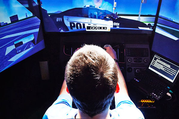 young male sitting behind police simulator