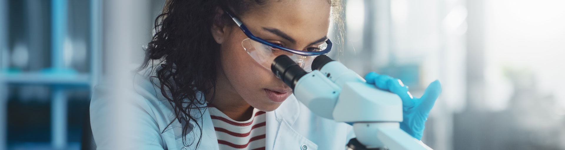 person looking into microscope