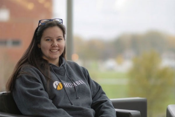 Emma Patten wearing a Humber sweater sitting at Lakeshore Campus