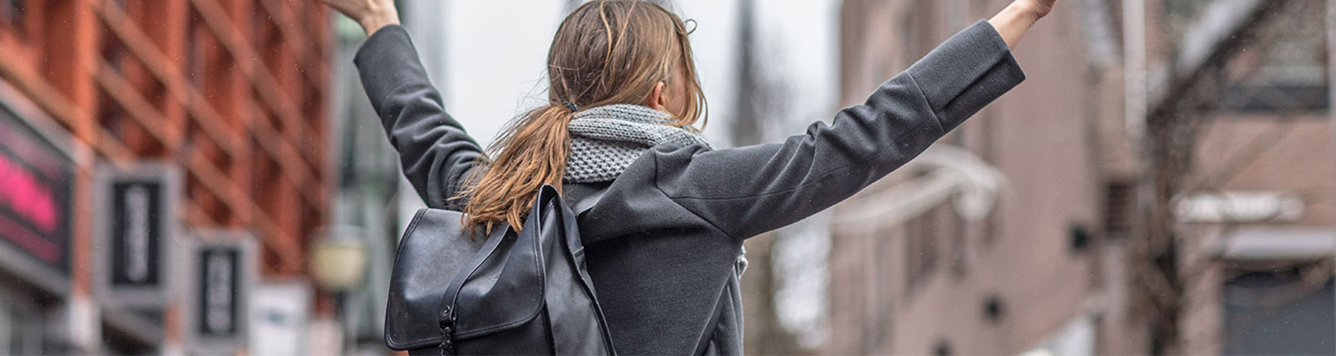 back of female holding arms in the air