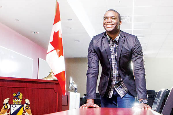 man smiling in a mock courtroom