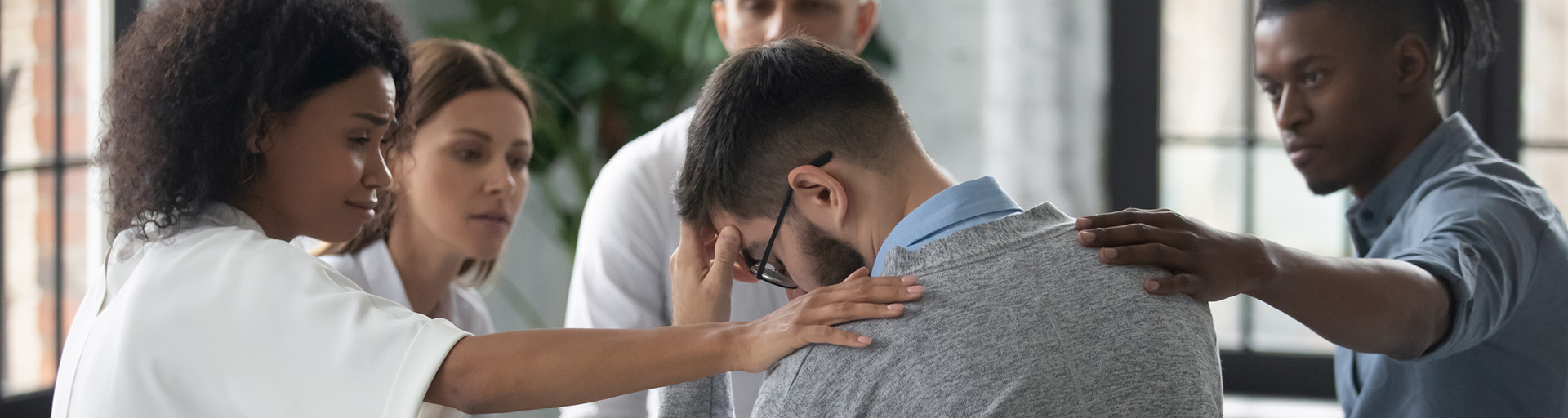 group of people sitting in a circle comforting someone