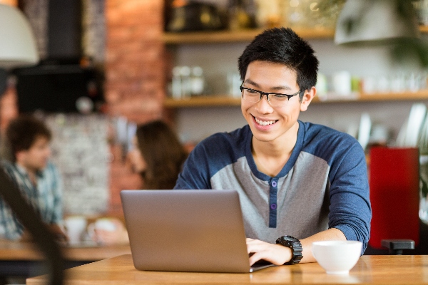 Smiling male student on a laptop