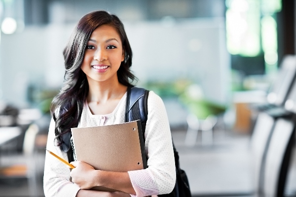 Smiling female student holding papers