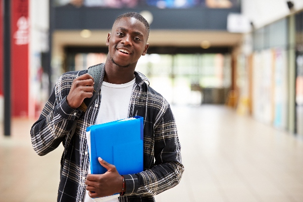 Smiling male student holding a backpack