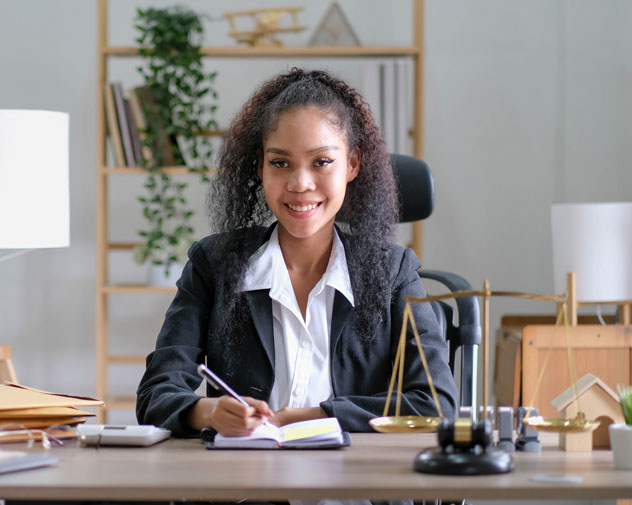 Professional writing at a desk with a balancing scale on the table