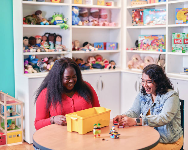 two students playing with a toy in the play sim lab