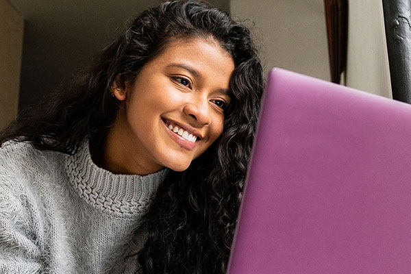 female sitting smiling looking at laptop