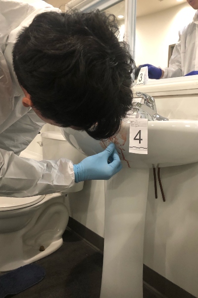Forensic student examining bathroom sink