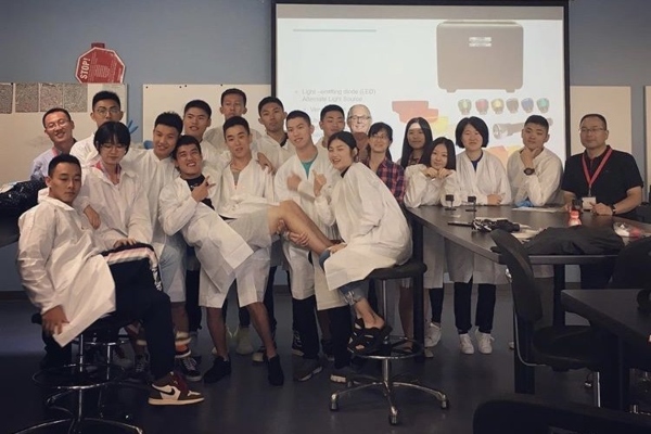 A group of Global Summer School students in class wearing lab coats