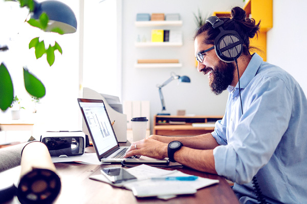 Man working on laptop with headphones on