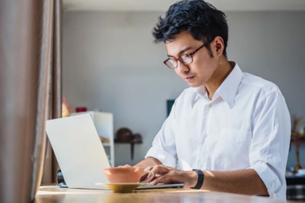 male student typing on laptop