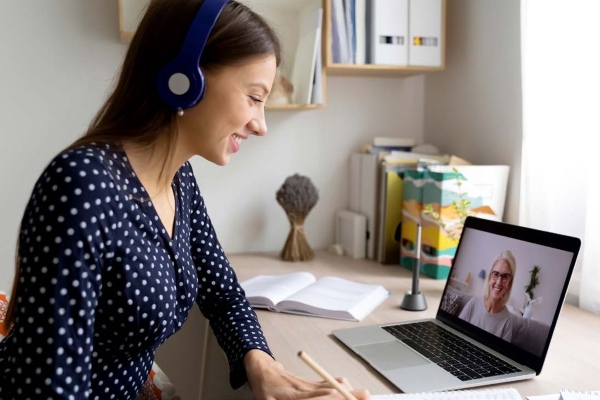 woman looking at laptop with headphones on
