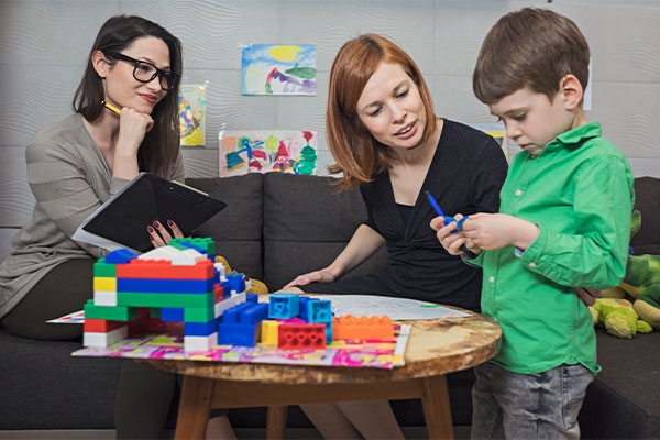 social worker observing a child playing with blocks