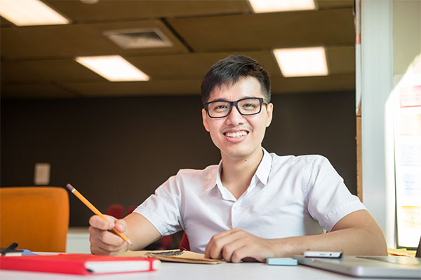 Male student holding a pencil