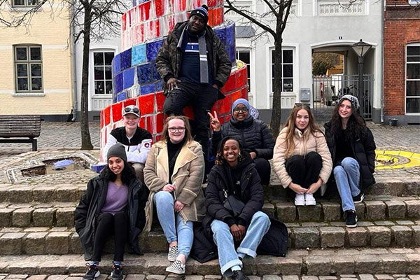 group of students posing in front of a art sculpture in Denmark