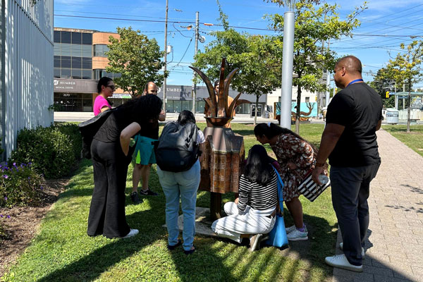 People gathered outside around a statue