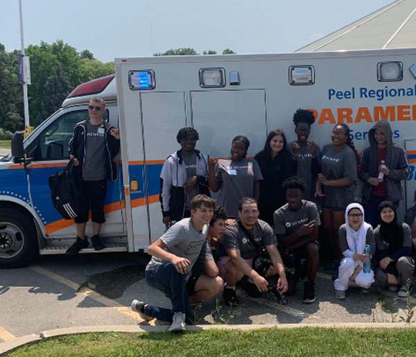 People taking group photo in front of ambulance