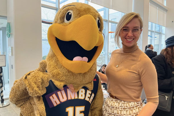 Person posing with Humber mascot