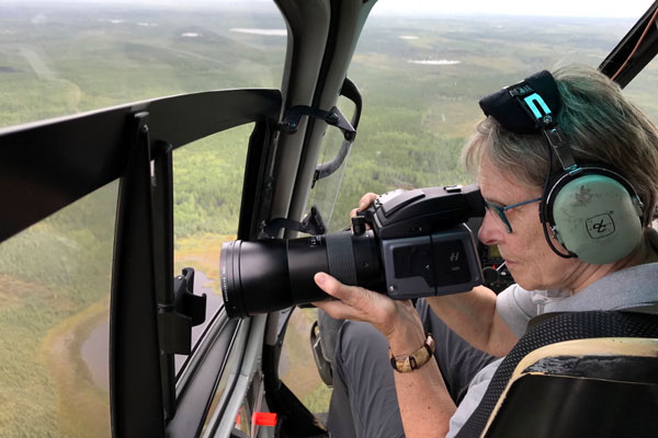 Roberta Bondar in a helicopter holding camera