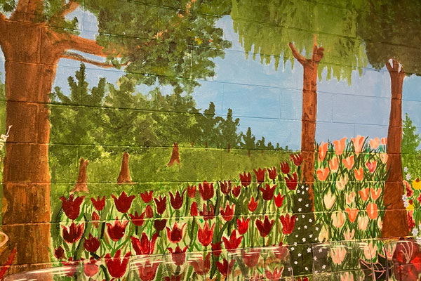 Painted wall mural of trees and flowers