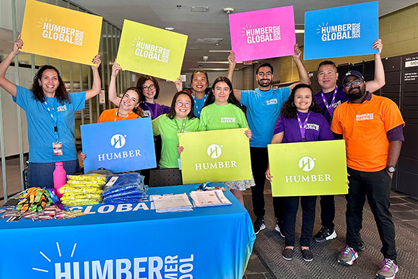 Humber students holding Humber global signs