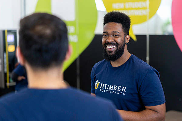 Humber student wearing a Humber shirt and smiling