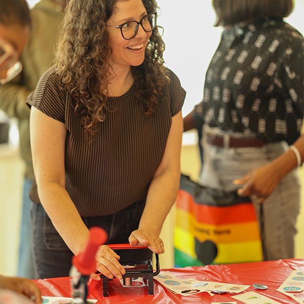 person smiling and cutting out buttons