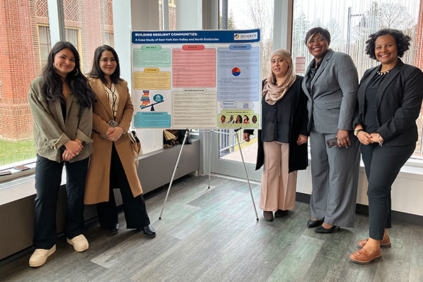 group of students standing in front of a poster presentation