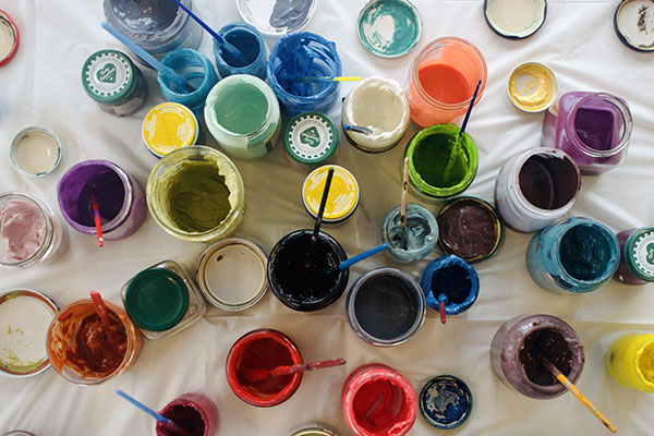 jars of opened paint sitting on white table cloth