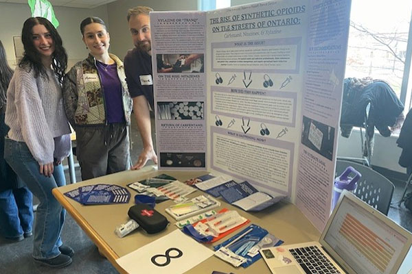 people stand by a display about synthetic opioids.