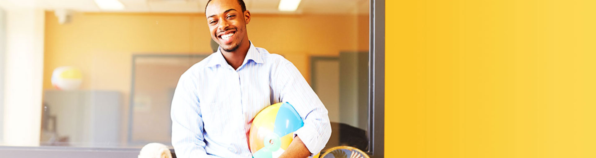 male holding a beach ball in classroom setting