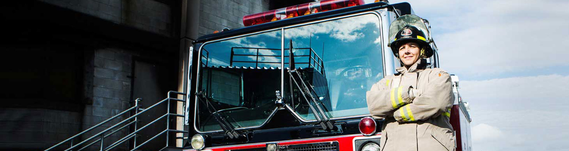 student firefighter standing in front of firetruck